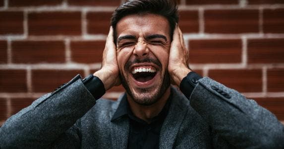 Man holding his ears while screaming © iStock