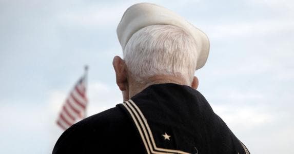 Veterans can use VA health care in retirement Senior veteran looking at American flag | EyeJoy/E+/Getty Images