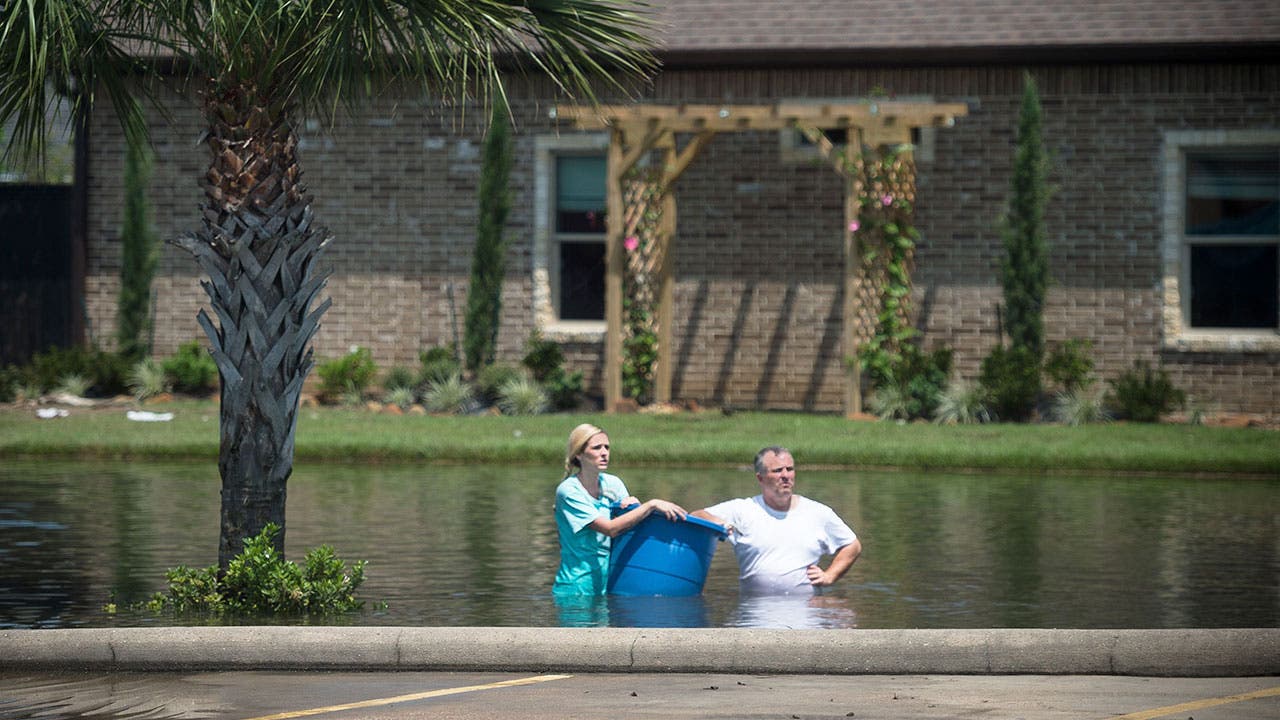 A couple wading in floodwaters