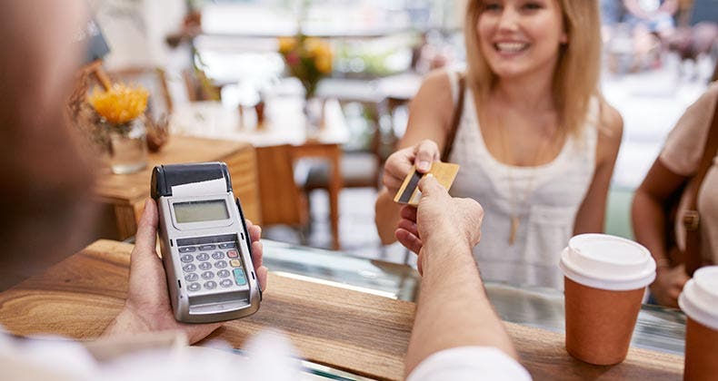 Woman paying for her coffee with a credit card