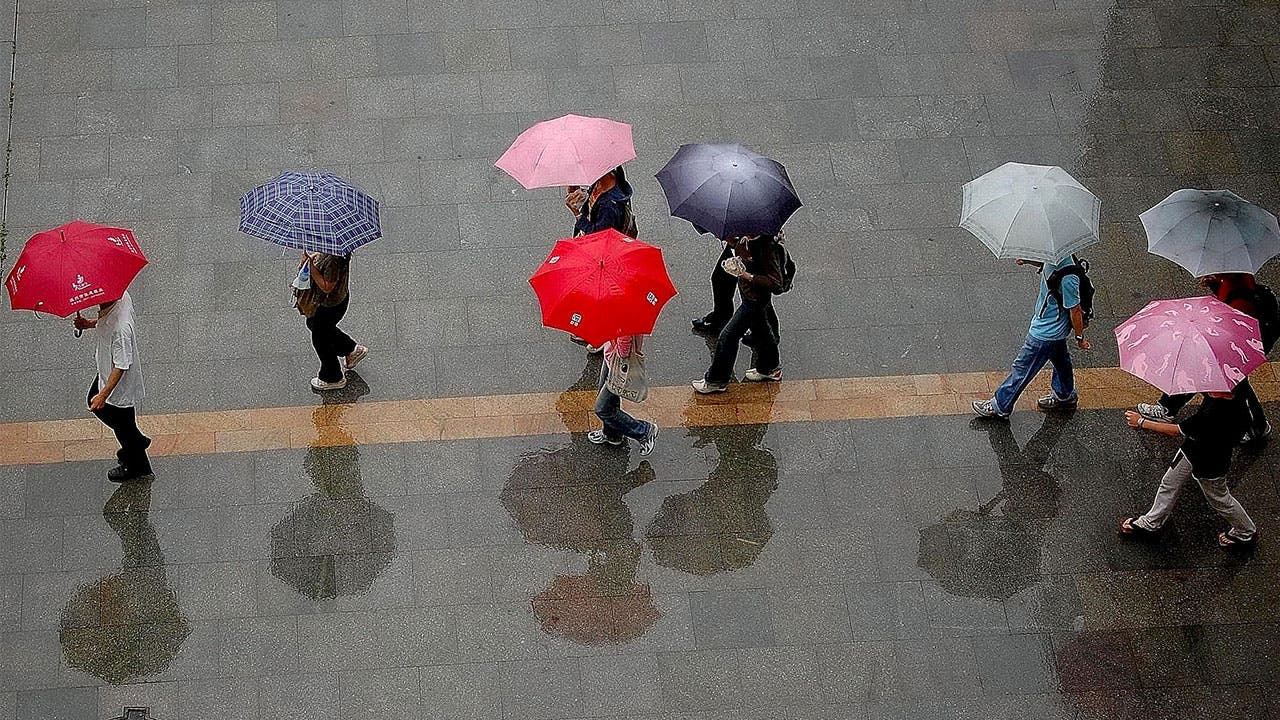 people walking through the rain with umberellas