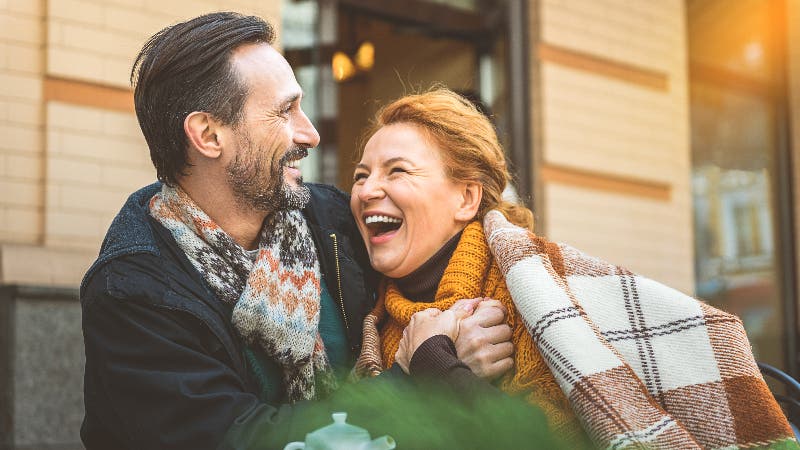 Older couple laughing at cafe