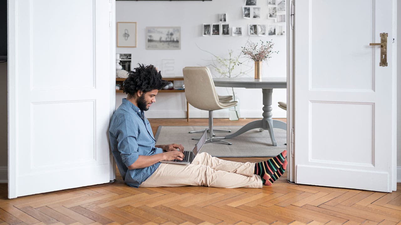 Man sitting on floor and using laptop