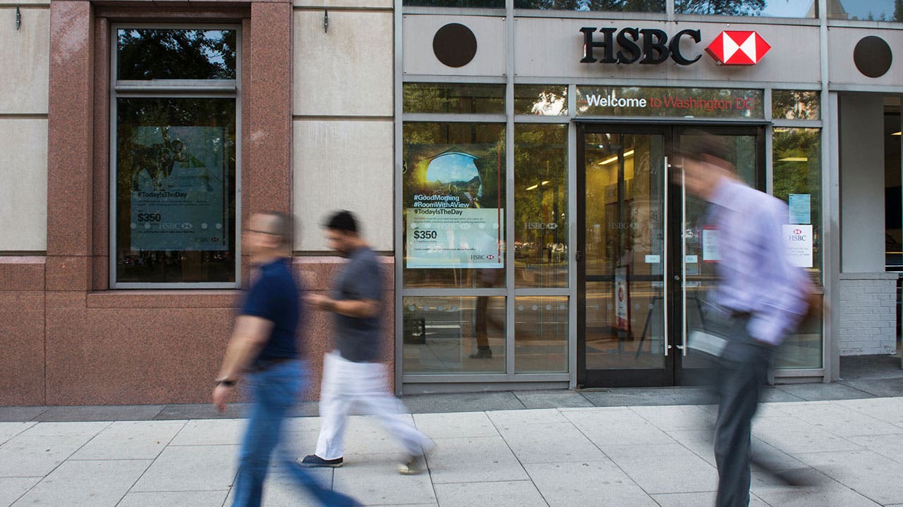 People walking past an HSBC Bank