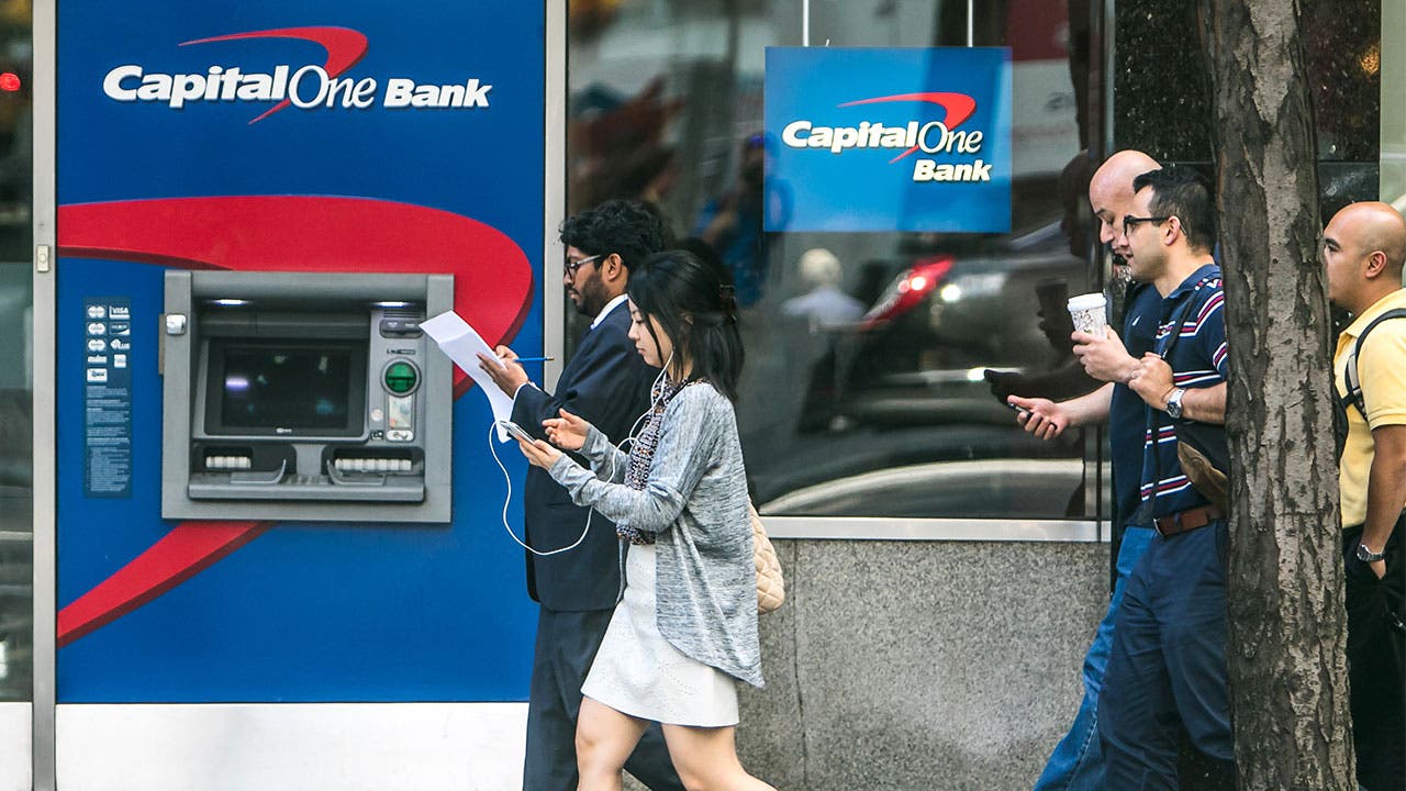 People walking past a Capital One bank