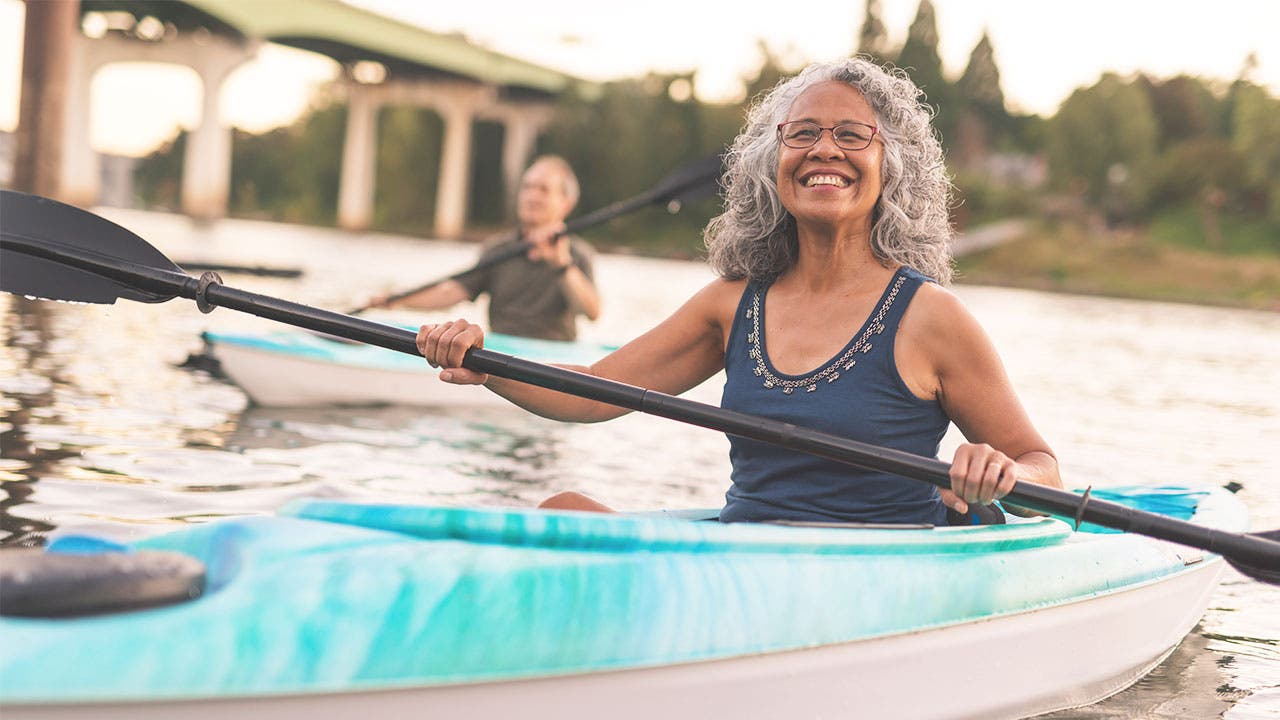 Seniors kayaking along a river