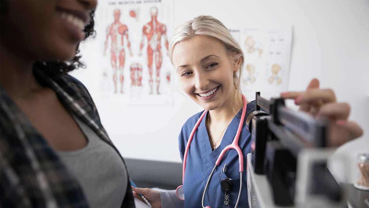 Nurse weighing patient