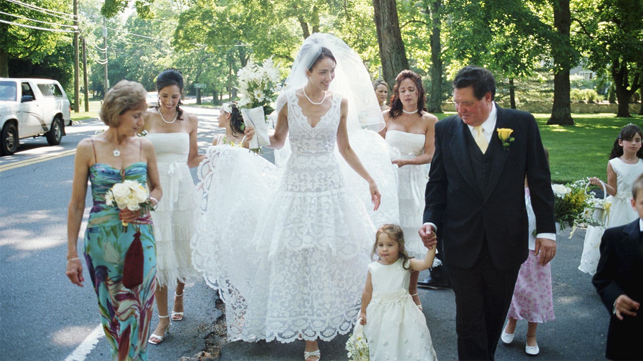 Bride and wedding party walk in street