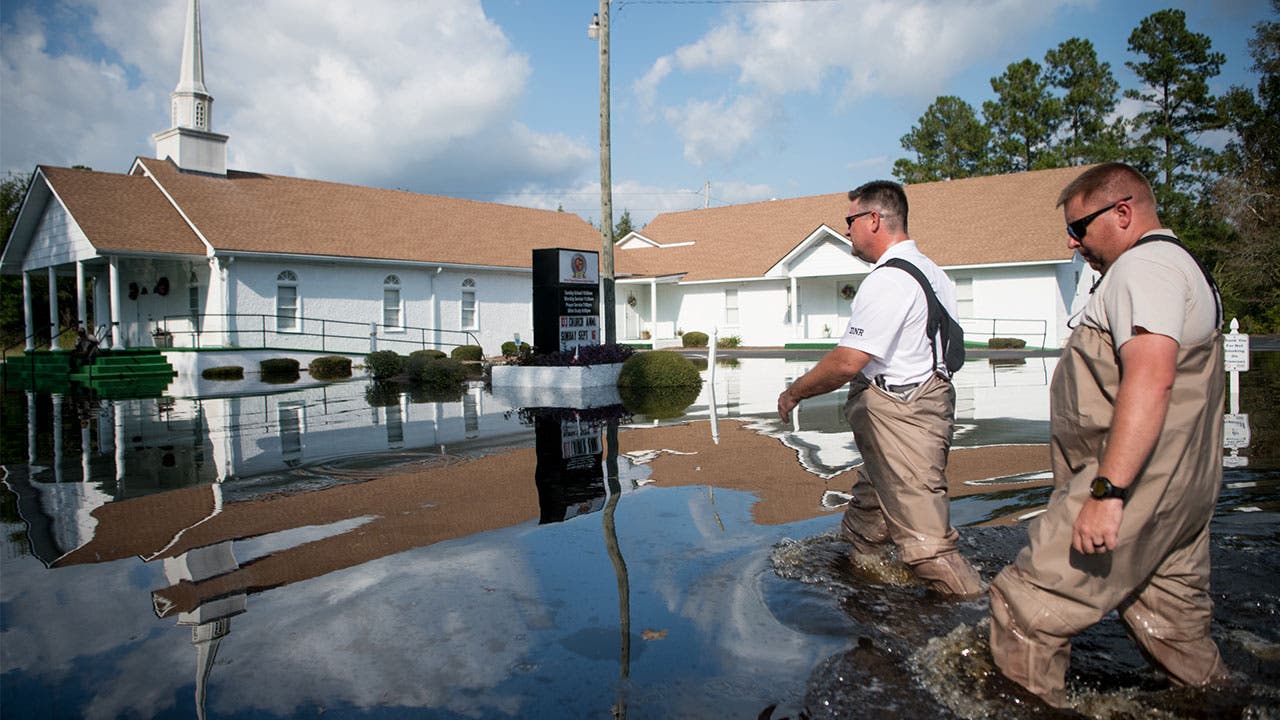 Men walking past church in the aftermath of Hurricane Florence