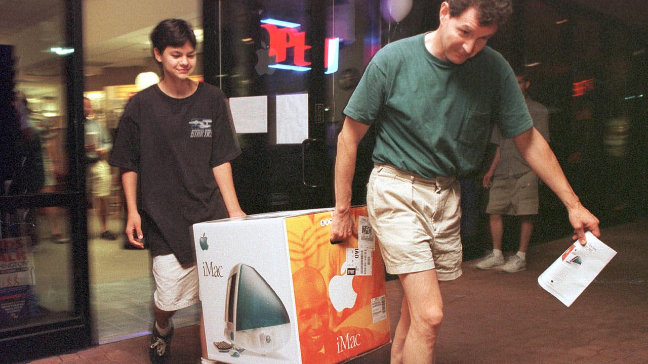 Father and son carrying an iMac