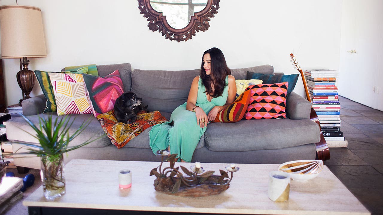 Woman sits with her dog on couch