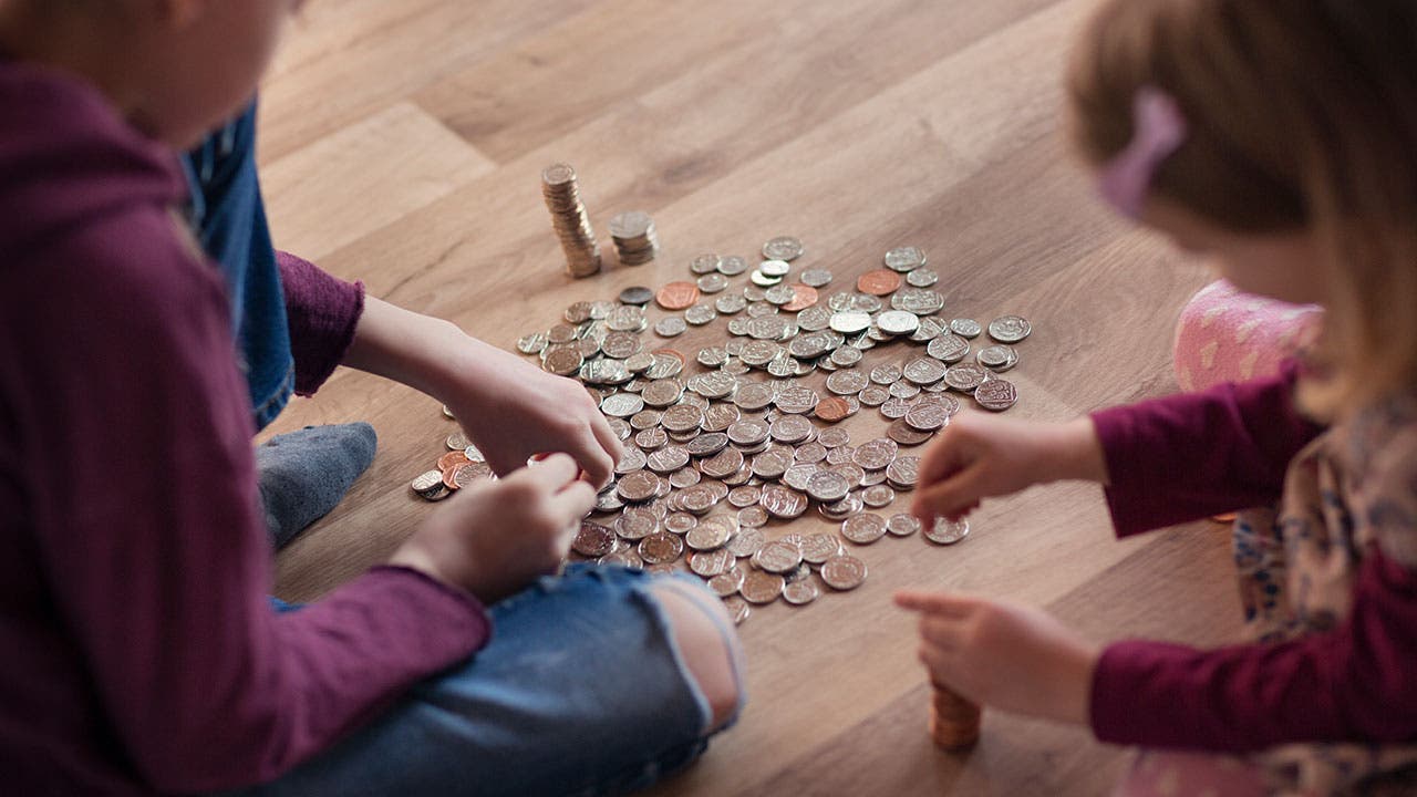 Two young girls counting coins