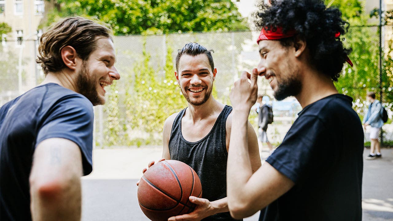 Friends playing basketball in park