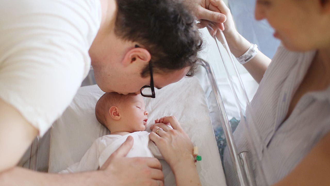 New parents embrace newborn