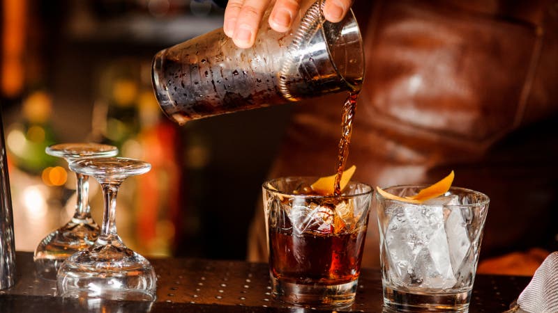 barman pouring alcoholic drink in bar