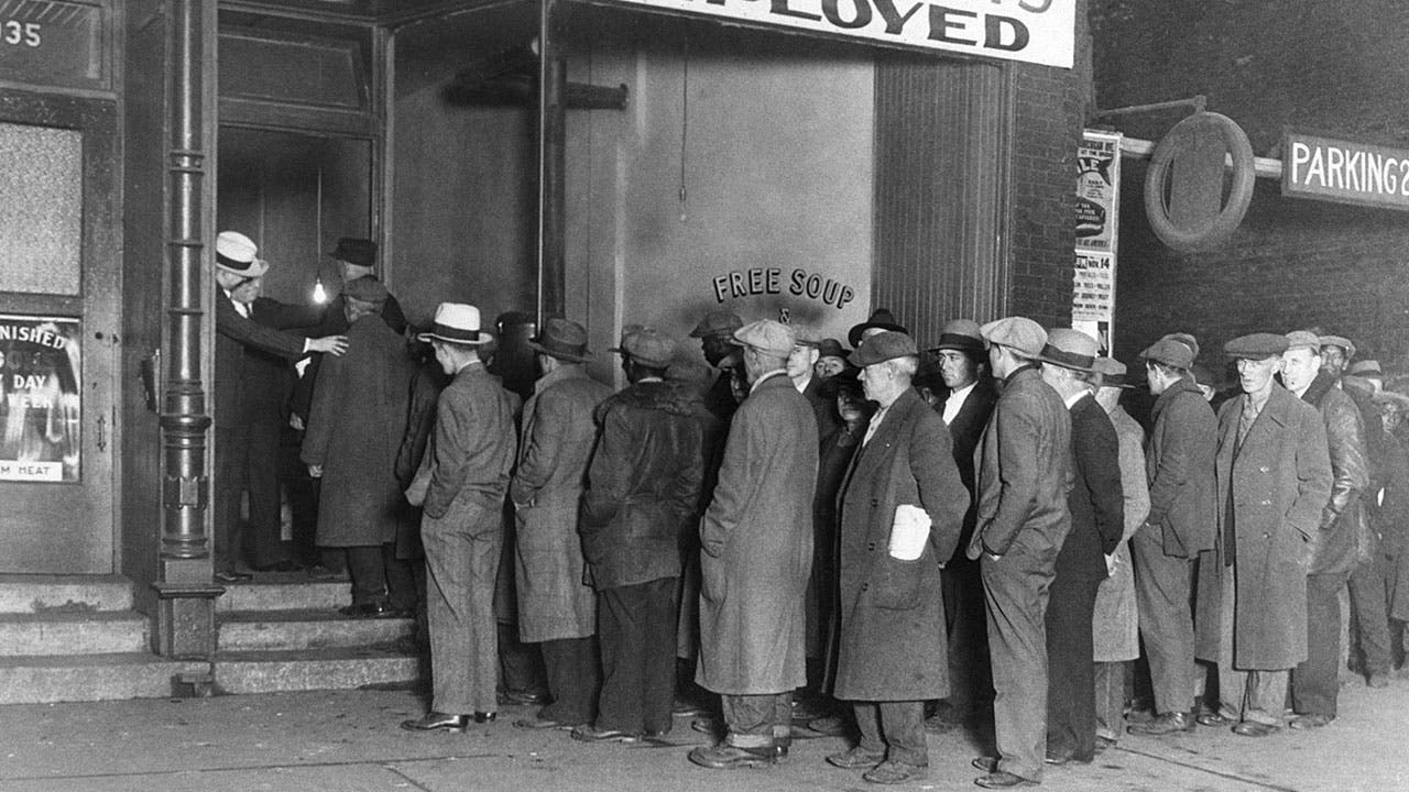 Men stand in line at a soup kitchen during the Great Depression