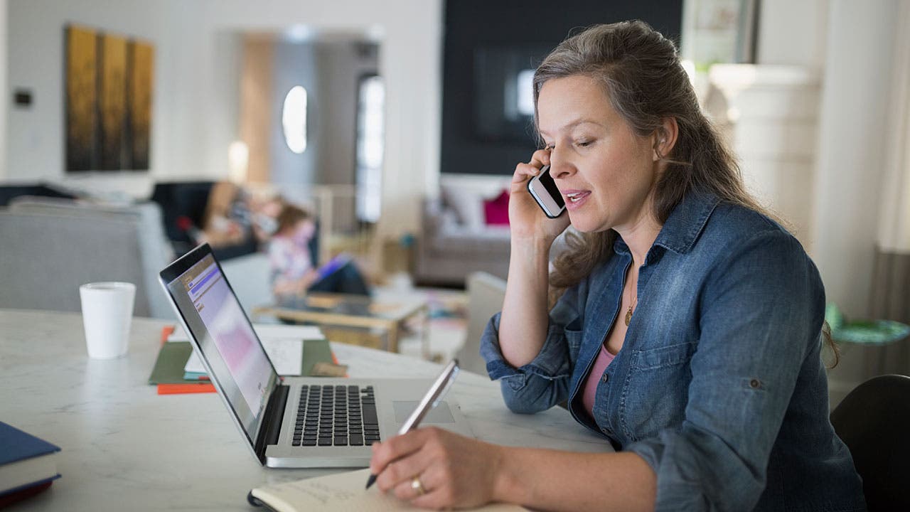 Woman on phone making notes