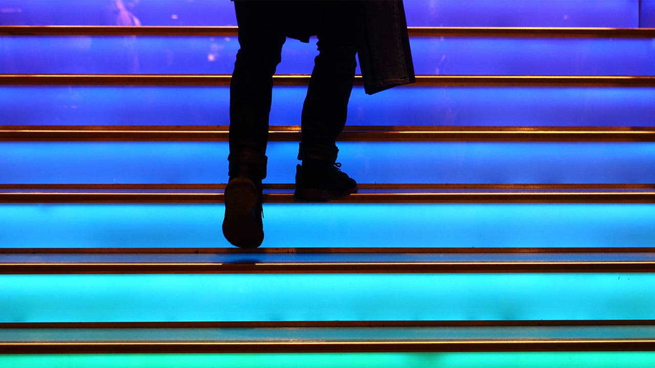 Man walking up the colored stairs