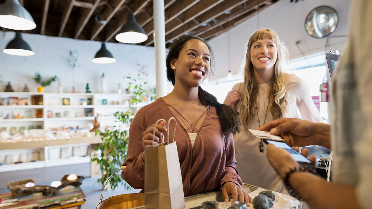 Friends shopping and paying with a credit card