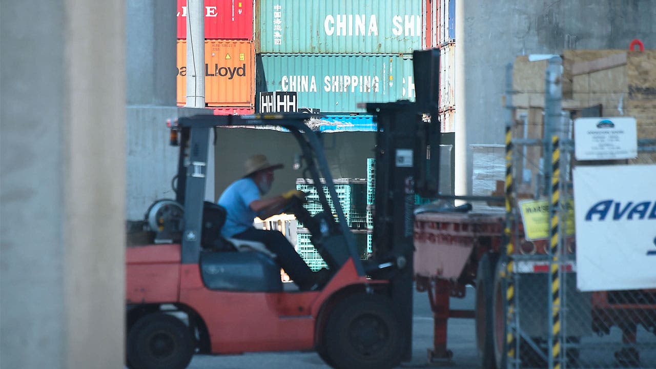 Man using a forklife to move Chinese containers