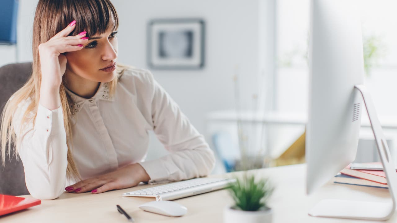 Woman looking at computer, troubled