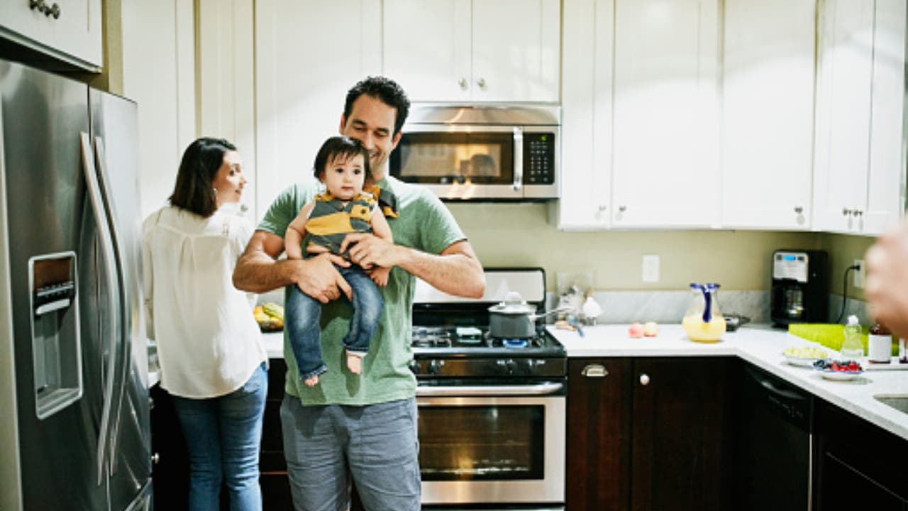 Image of a family in an insured house playing with their baby.