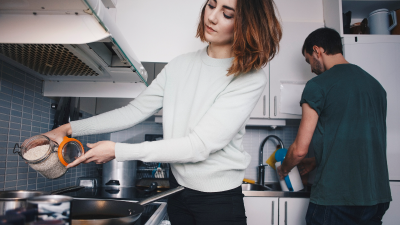 Young roommates preparing food in apartment
