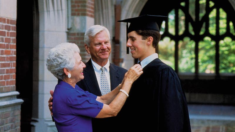 Two grandparents congratulate a young college graduate
