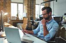 Businessman reviewing paperwork in empty office