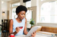 Person looking at tablet with credit card