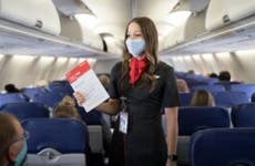 Flight attendant gives instructions wearing protective mask